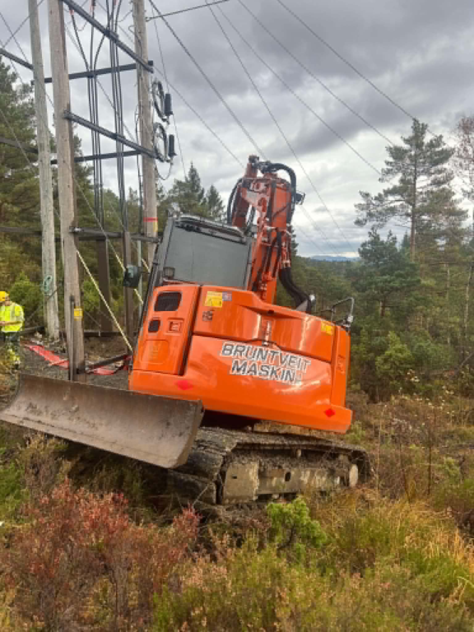 Gravemaskin i skogsterreng