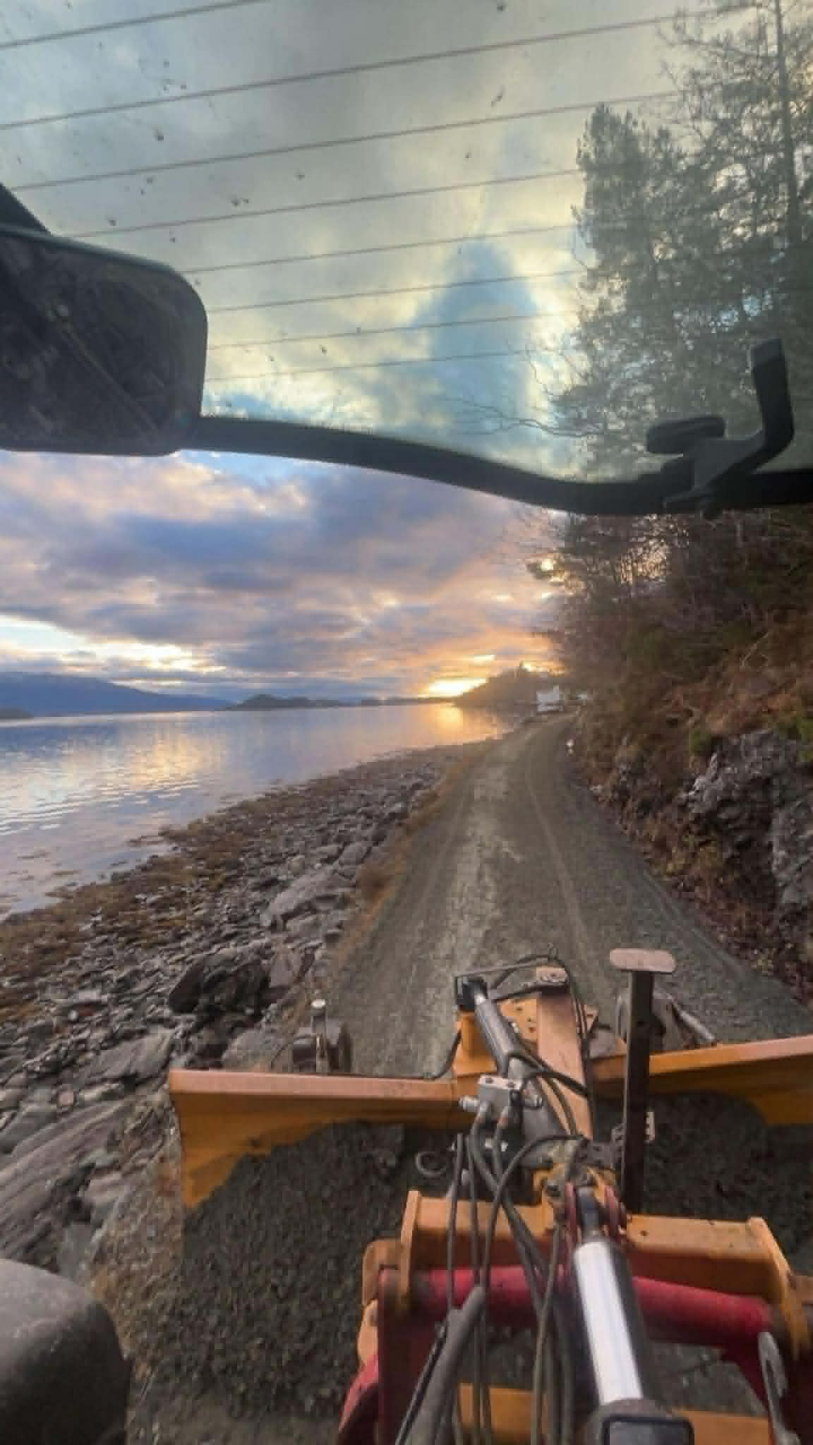 Utsikt fra maskin ved solnedgang over fjorden